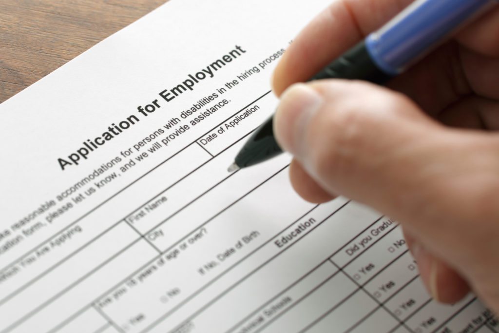 Completing an employment application form with focus on heading