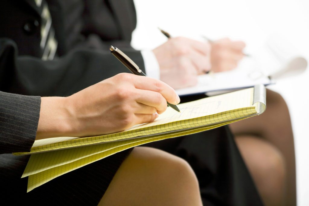 Close-up of business people hands with document writing at lecture